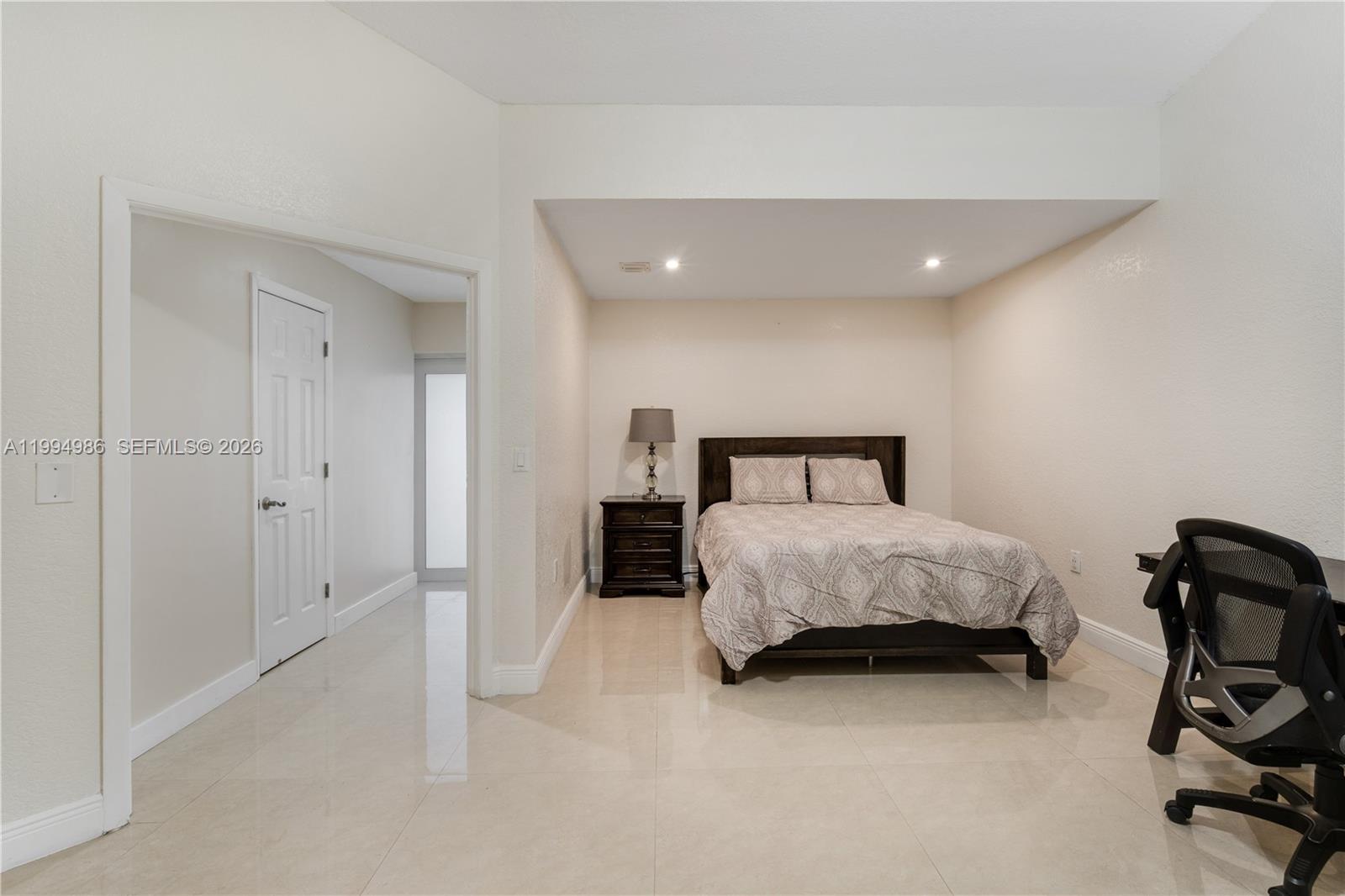 15250 Southwest 154th Terrace, Unit A Miami, FL 33187 - Photo 1 of 16 a bedroom with a bed and a chair