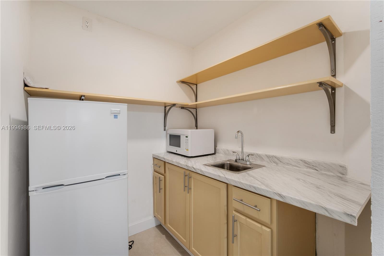 15250 Southwest 154th Terrace, Unit A Miami, FL 33187 - Photo 16 of 16 a kitchen with a sink and refrigerator