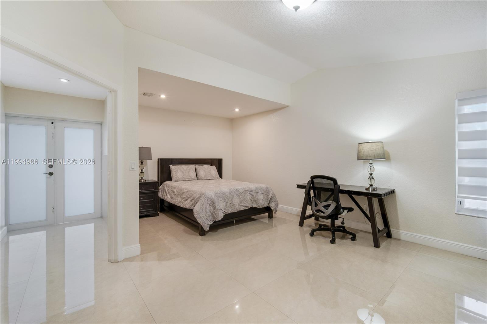 15250 Southwest 154th Terrace, Unit A Miami, FL 33187 - Photo 7 of 16 a bedroom with a bed and a table