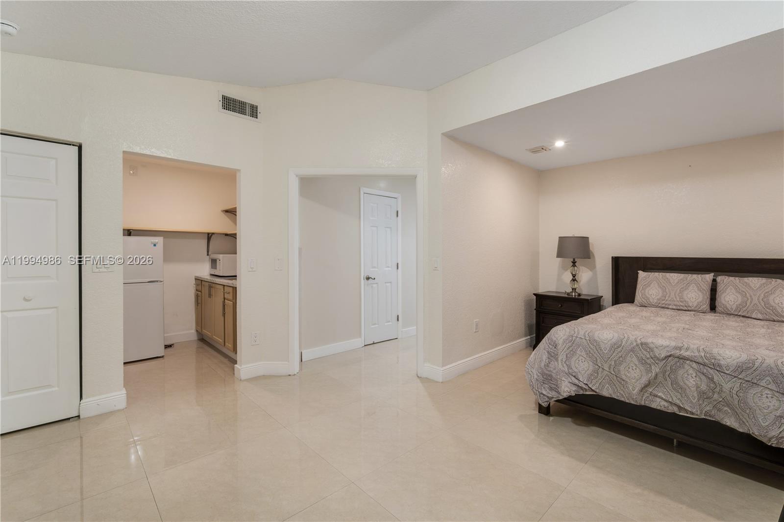 15250 Southwest 154th Terrace, Unit A Miami, FL 33187 - Photo 8 of 16 a bedroom with a bed and a view of bathroom
