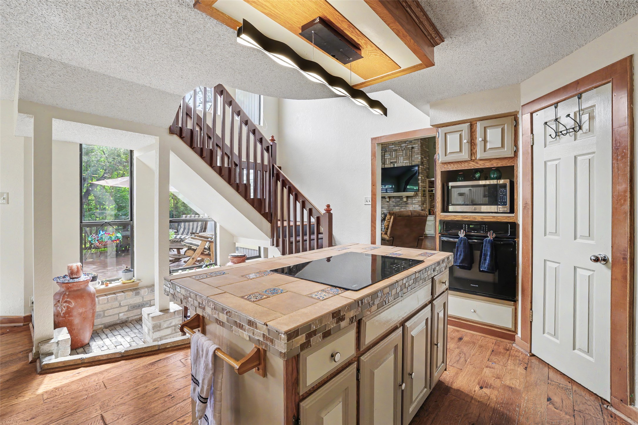 110 South Ridge Circle Georgetown, TX 78628 - Photo 11 of 37 Kitchen island with a built-in cooktop, tile countertop, and integrated cabinetry