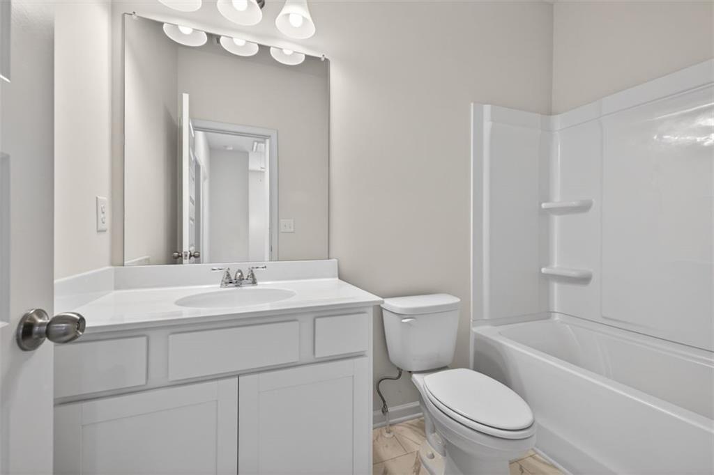 1007 Stiles Court, Unit 48 Cartersville, GA 30120 - Photo 18 of 34 a bathroom with a toilet a sink a mirror a window and vanity
