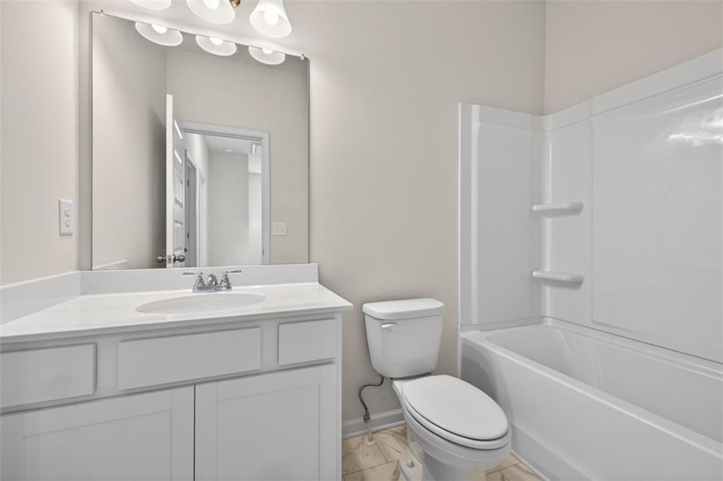 1007 Stiles Court, Unit 48 Cartersville, GA 30120 - Photo 19 of 34 a bathroom with a toilet a sink a mirror a bathtub and vanity
