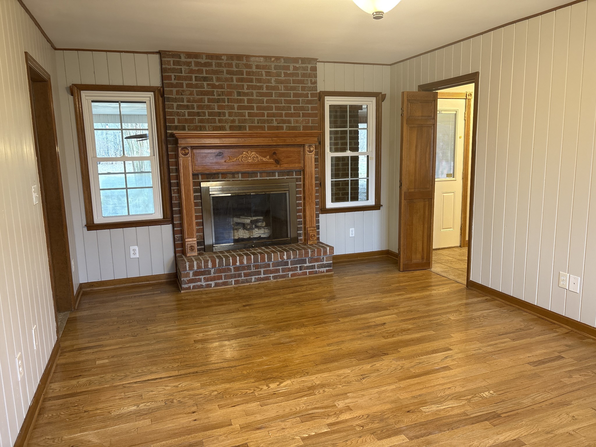 703 12 Oaks Road Tullahoma, TN 37388 - Photo 12 of 46 an empty room with a fireplace and windows