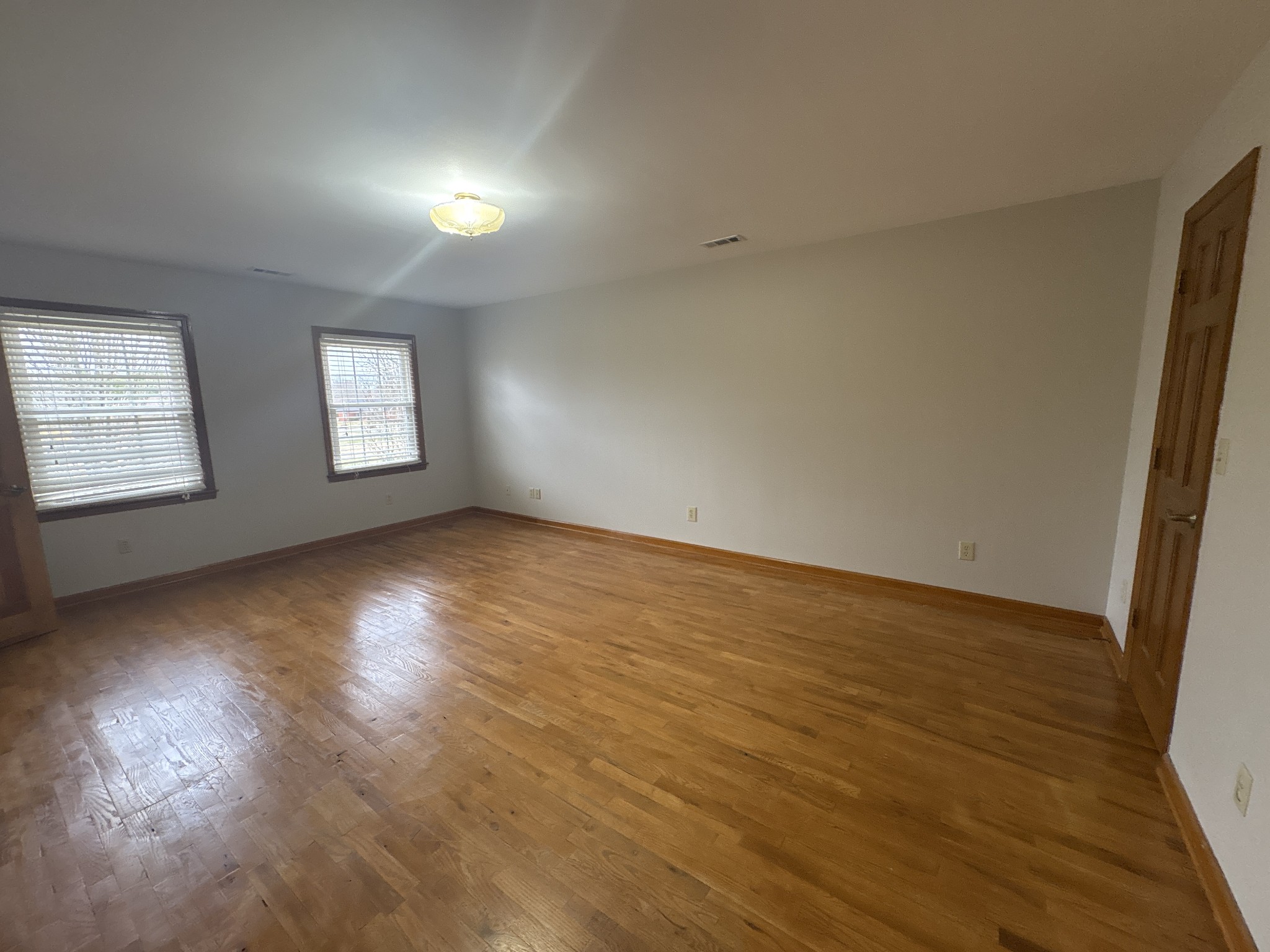 703 12 Oaks Road Tullahoma, TN 37388 - Photo 19 of 46 an empty room with wooden floor and windows