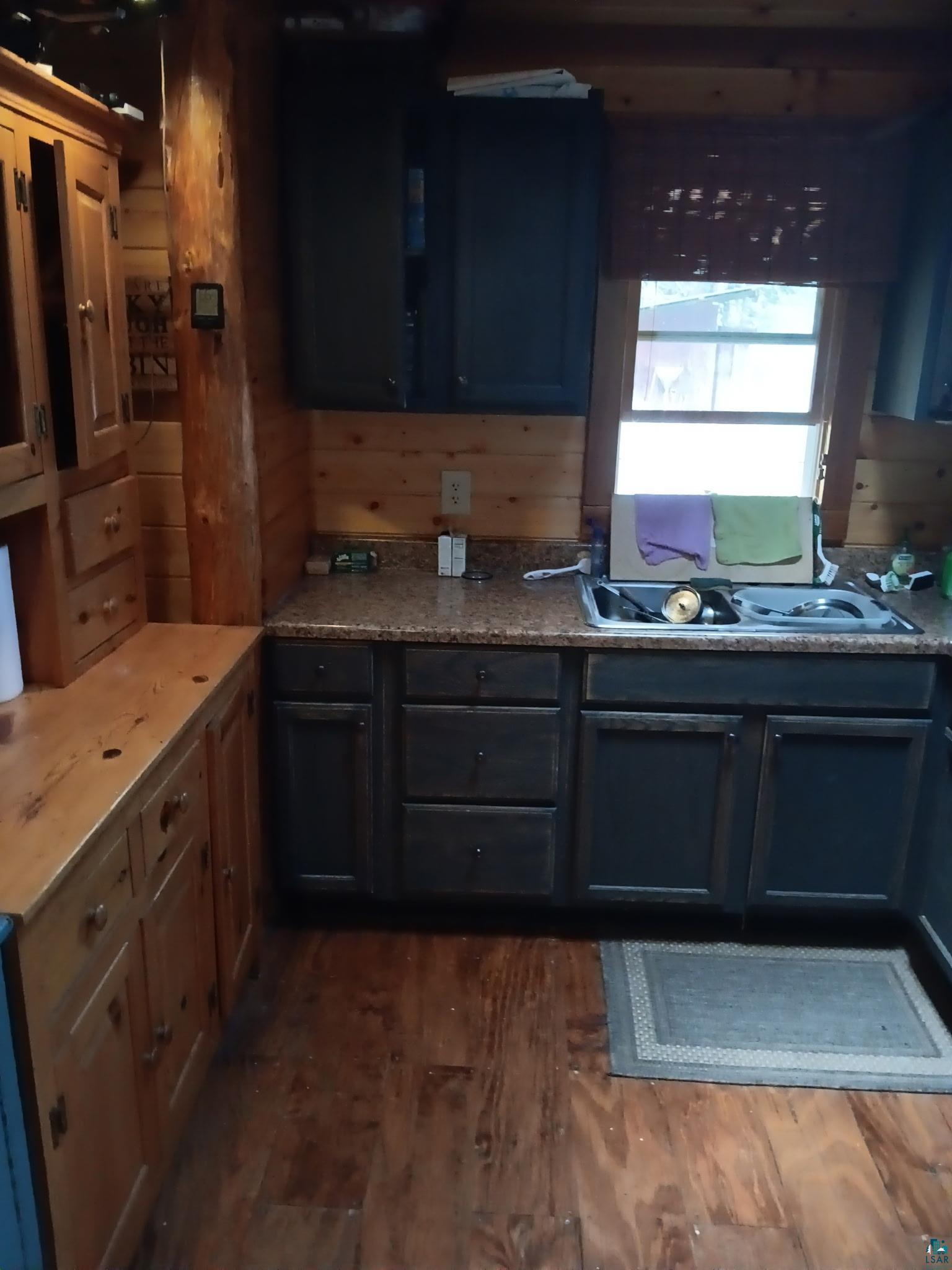 4002 Shilo Trail Ely, MN 55731 - Photo 6 of 15 Kitchen featuring dark wood-style floors and wooden walls