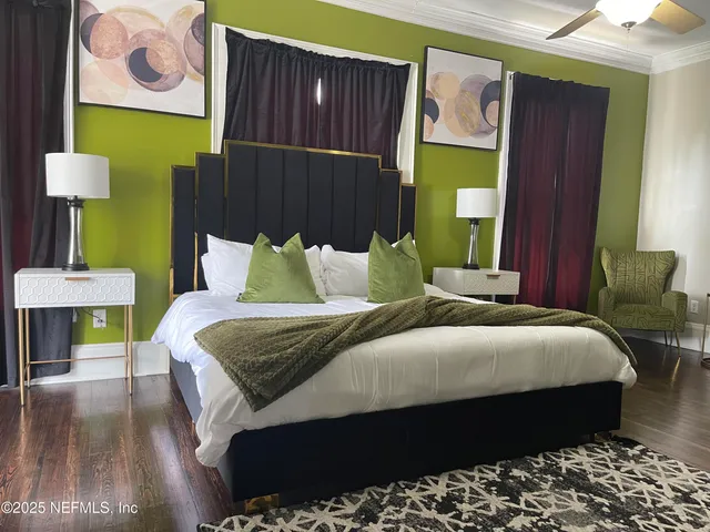 a bedroom with a bed lamps and wooden floor