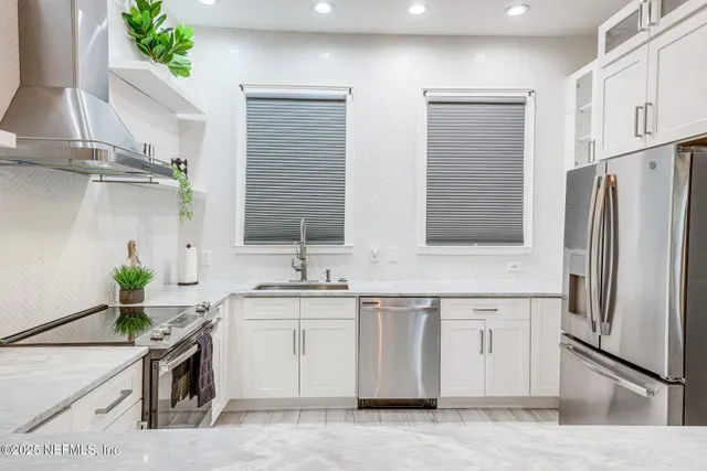 a kitchen with stainless steel appliances a sink a stove a refrigerator cabinets and a counter top space