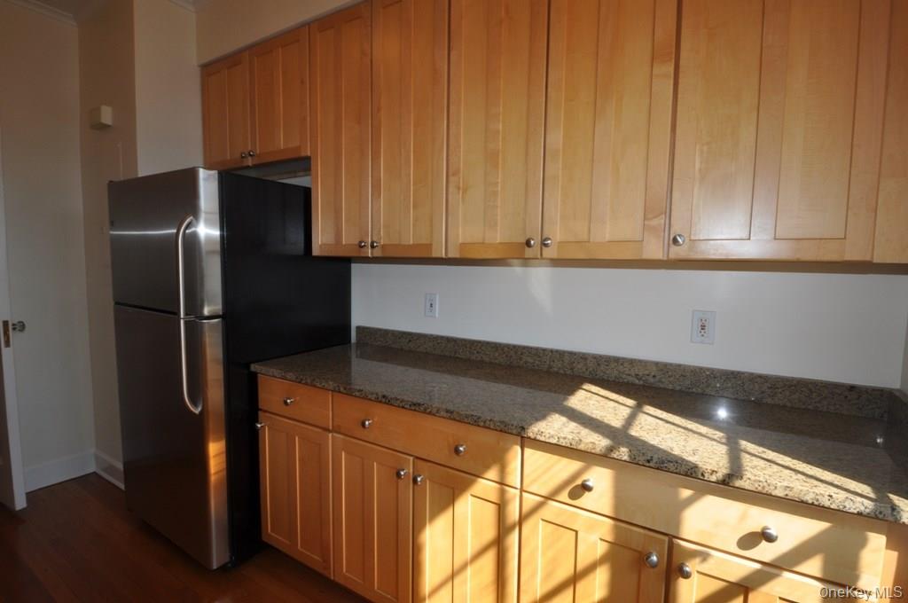 155 Garth Road, Unit 5H Scarsdale, NY 10583 - Photo 11 of 30 a kitchen with stainless steel appliances granite countertop a refrigerator and a sink