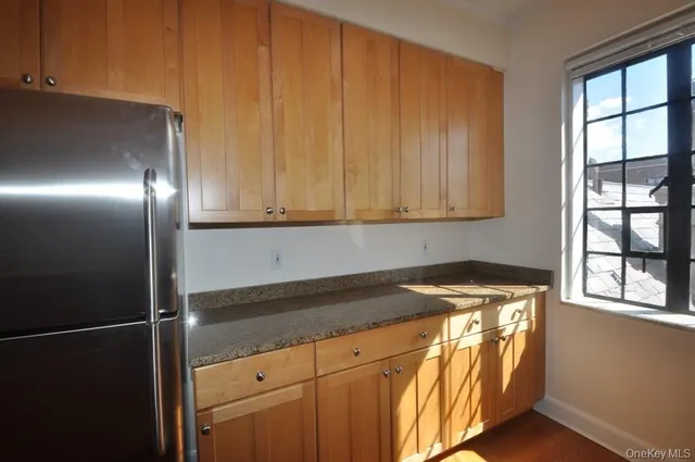 a kitchen with stainless steel appliances granite countertop a sink a stove and a refrigerator