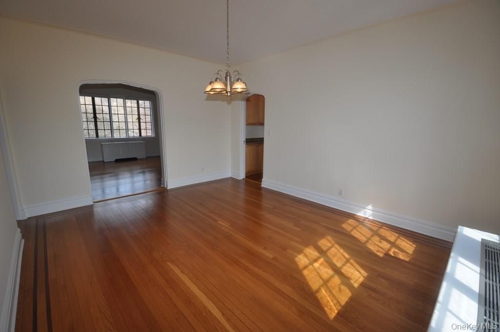 155 Garth Road, Unit 5H Scarsdale, NY 10583 - Photo 18 of 30 an empty room with wooden floor and windows