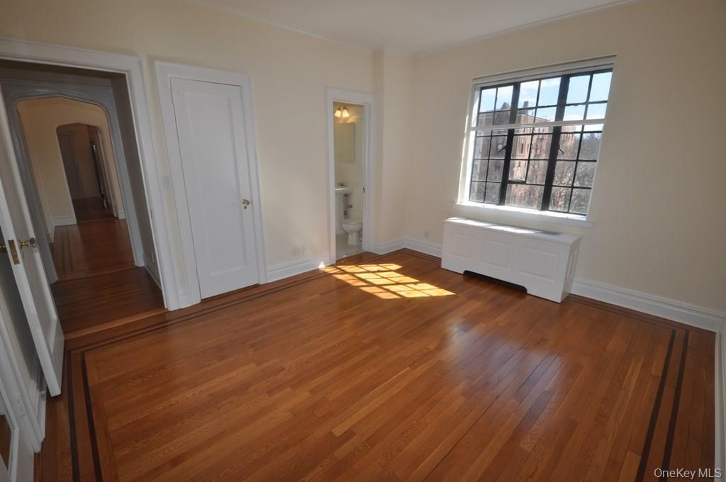 155 Garth Road, Unit 5H Scarsdale, NY 10583 - Photo 20 of 30 a view of an empty room with wooden floor and a window