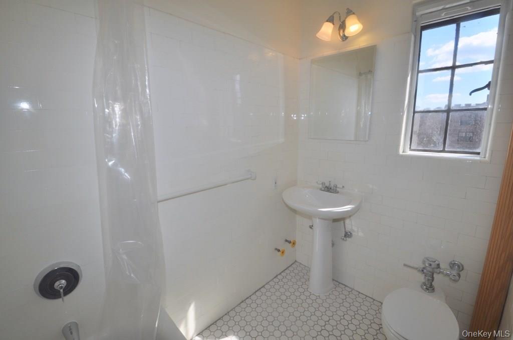 155 Garth Road, Unit 5H Scarsdale, NY 10583 - Photo 23 of 30 a bathroom with a sink a toilet and shower