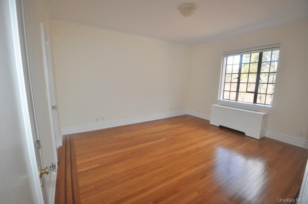 155 Garth Road, Unit 5H Scarsdale, NY 10583 - Photo 24 of 30 an empty room with wooden floor and windows