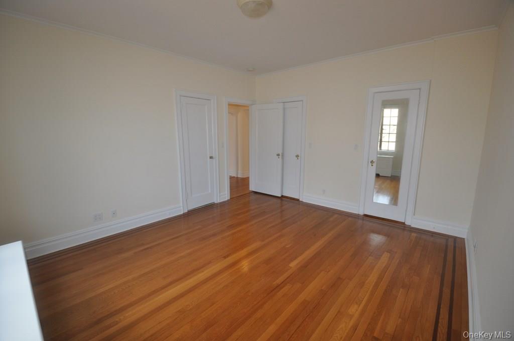 155 Garth Road, Unit 5H Scarsdale, NY 10583 - Photo 26 of 30 a view of empty room with wooden floor and fan