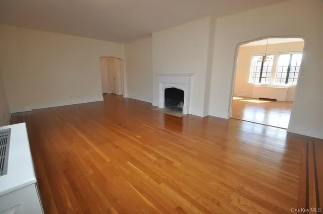 a view of empty room with wooden floor and fireplace