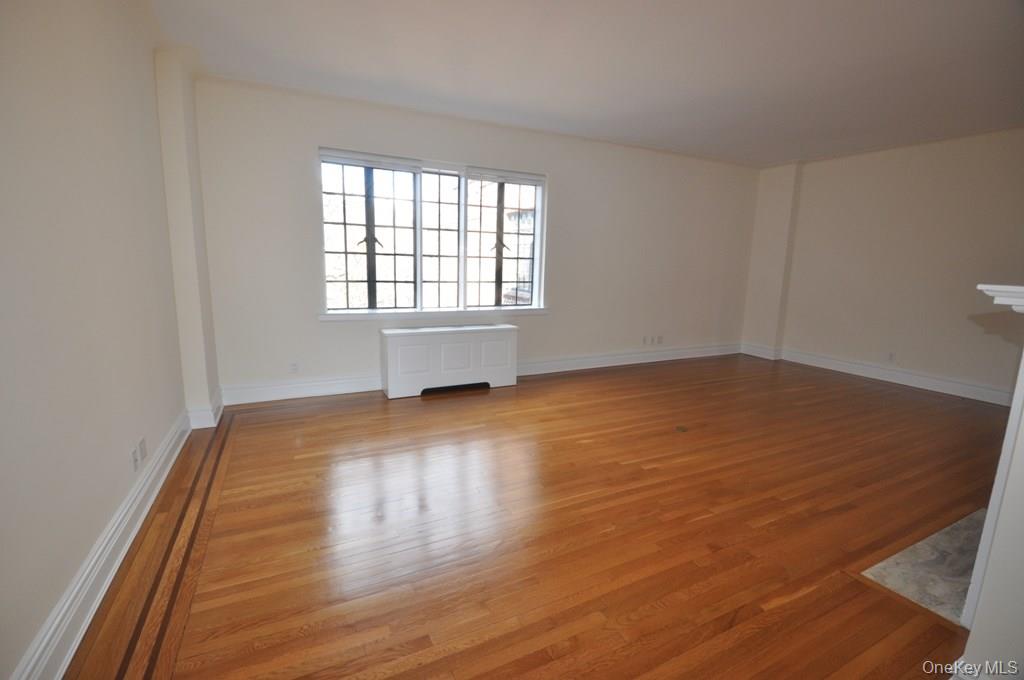155 Garth Road, Unit 5H Scarsdale, NY 10583 - Photo 4 of 30 wooden floor in an empty room with a window