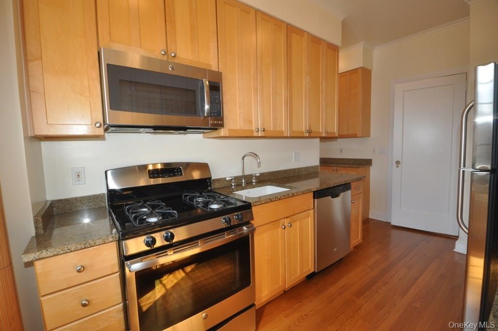 155 Garth Road, Unit 5H Scarsdale, NY 10583 - Photo 8 of 30 a kitchen with stainless steel appliances granite countertop a stove a sink and a microwave