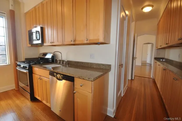 a kitchen with stainless steel appliances granite countertop a stove a sink and a refrigerator