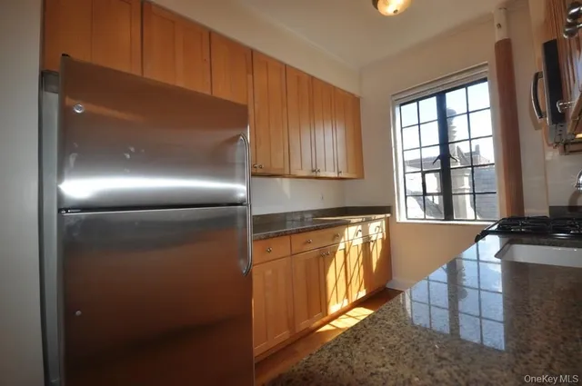 a kitchen with stainless steel appliances granite countertop a refrigerator and a sink
