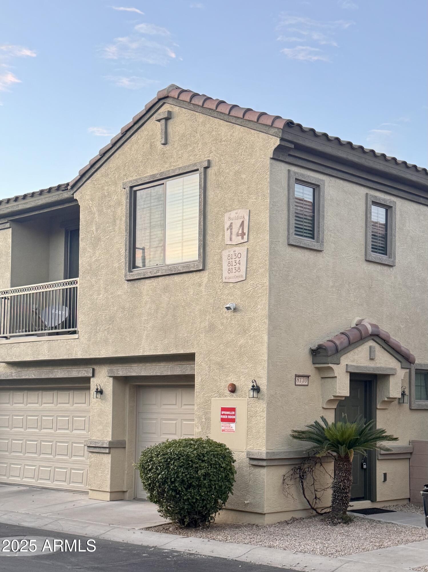 a front view of a house with plants