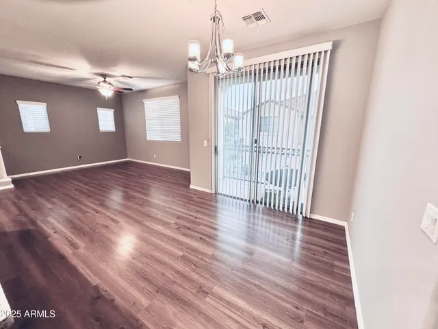 a view of a livingroom with wooden floor and a ceiling fan