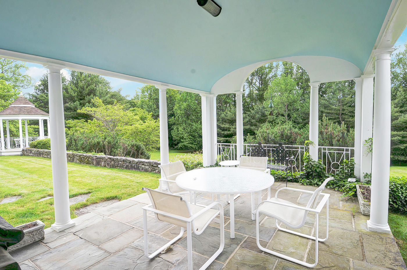 96 Woods End Road New Canaan, CT 06840 - Photo 17 of 21 a view of a patio with table and chairs under an umbrella