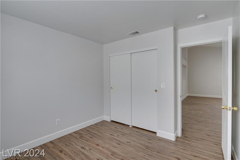 9660 Crystal Ridge Road Las Vegas, NV 89123 - Photo 15 of 18 A well-proportioned interior space showcasing durable wood flooring and functional sliding closet doors.
