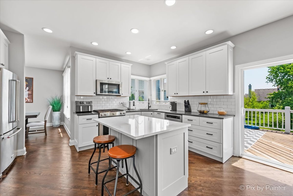 2 Shadow Creek Court Lake In The Hills, IL 60156 - Photo 11 of 44 a large kitchen with stainless steel appliances granite countertop a stove a sink dishwasher a microwave oven and a dining table with wooden floor