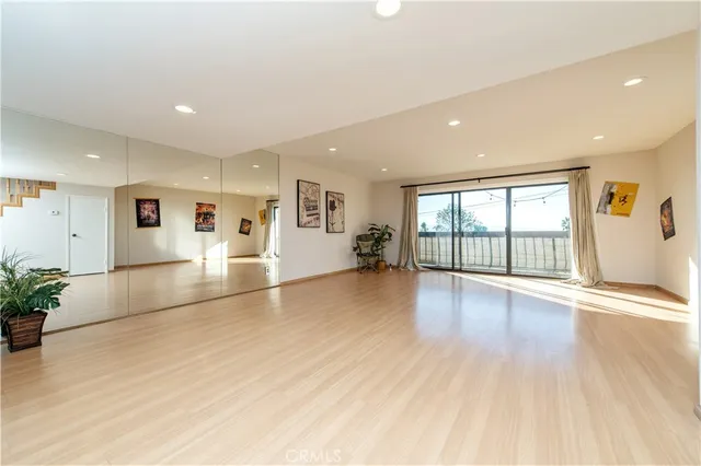 a living room with dining room and couches with wooden floor