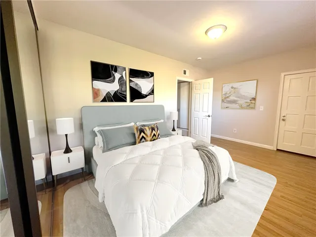 a bedroom with a bed and wooden floor