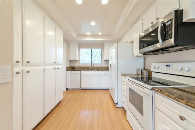 a view of a hallway with wooden floor and a bathroom