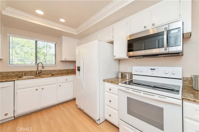 a kitchen with stainless steel appliances white cabinets and a microwave oven