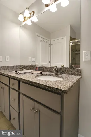 a bathroom with a granite countertop toilet sink and mirror