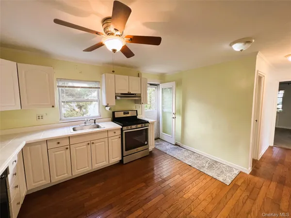 a large white kitchen with wooden floor