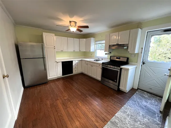a kitchen with a refrigerator a stove top oven a sink dishwasher and wooden floor