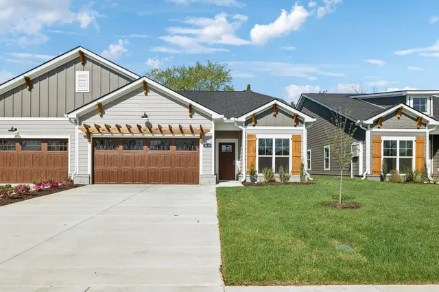 a front view of a house with a yard and trees