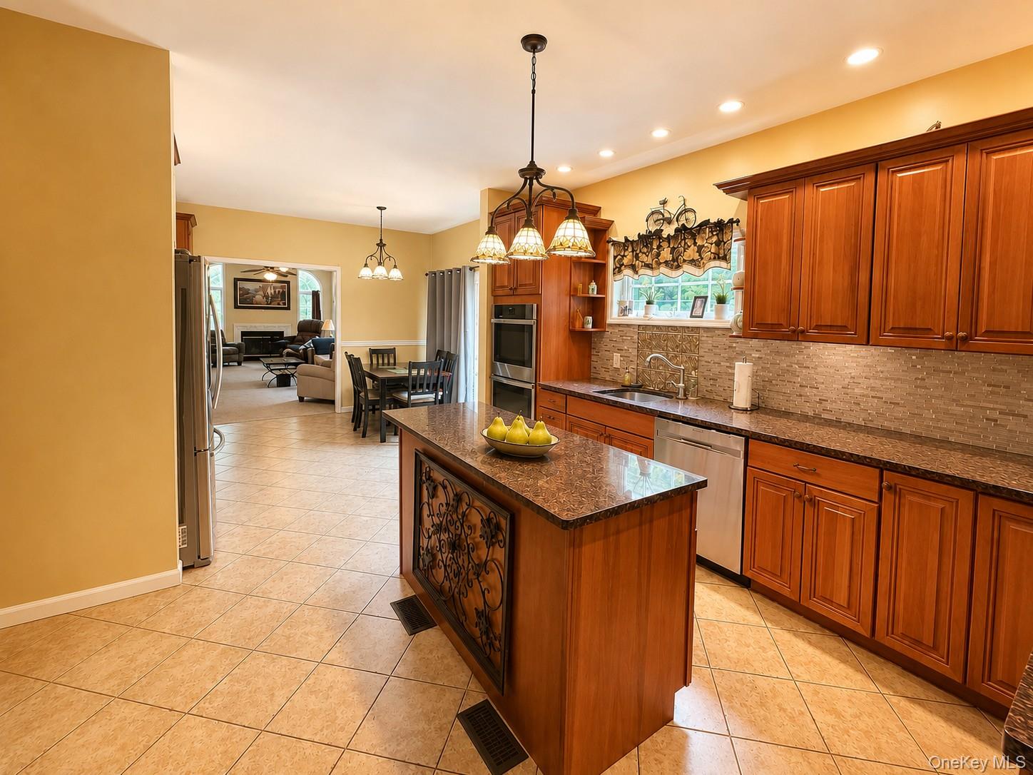 411 Mt Joy Road Middletown, NY 10941 - Photo 35 of 49 Kitchen featuring an island with a decorative panel, recessed lighting, tile flooring, wood cabinetry, and a tile backsplash