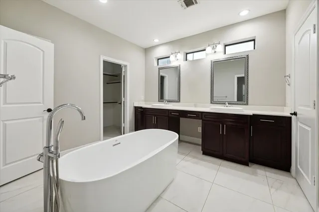 a bathroom with a tub sink and mirror