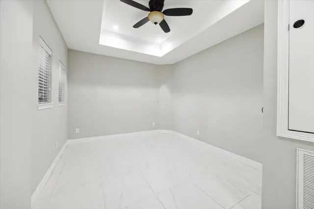 en empty room with ceiling fan and window