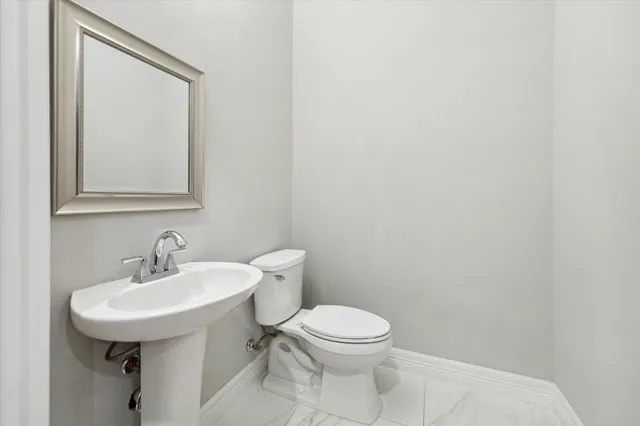 a white toilet sitting next to a bathroom sink