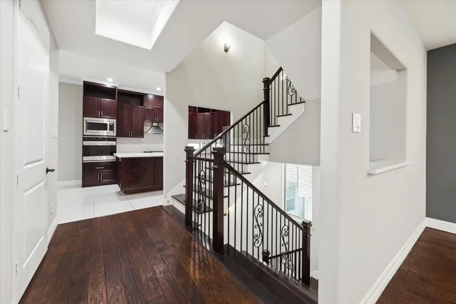 a view of a hallway with wooden floor and staircase