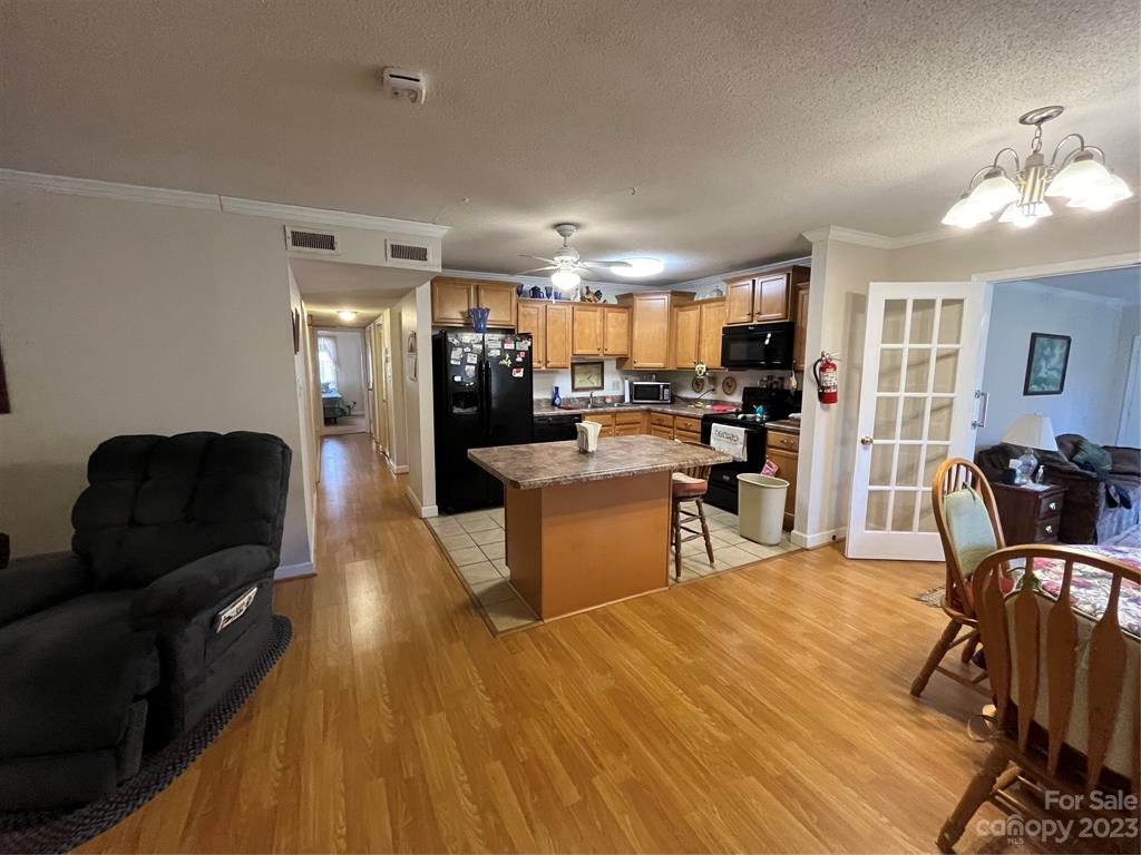 120 Barlow Lane Salisbury, NC 28147 - Photo 21 of 34 a kitchen with stainless steel appliances kitchen island granite countertop a refrigerator a stove a sink dishwasher a dining table and chairs with wooden floor