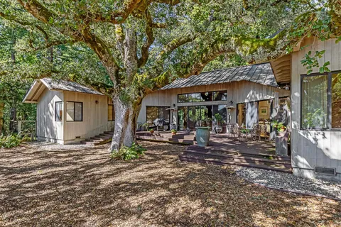 a view of a house with backyard and sitting area