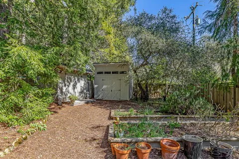 a view of a chair and fire pit in the middle of a yard