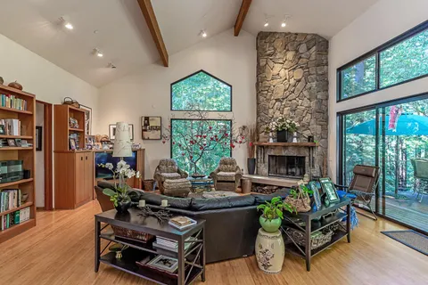 a living room with fireplace furniture and a floor to ceiling window