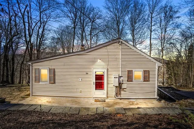 a view of a house with a yard and large tree