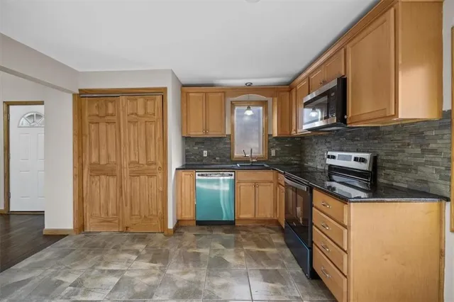 a kitchen with stainless steel appliances granite countertop a stove a sink and a microwave