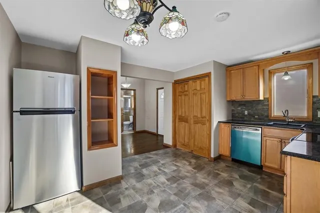 a kitchen with a refrigerator a sink and a stove top oven