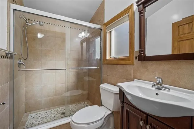 a bathroom with a sink toilet a mirror and shower